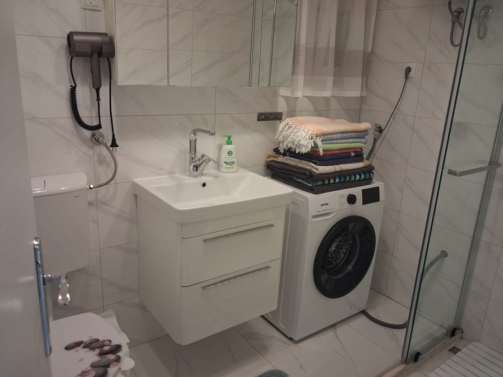 Modernes Badezimmer mit Dusche und Waschmaschine