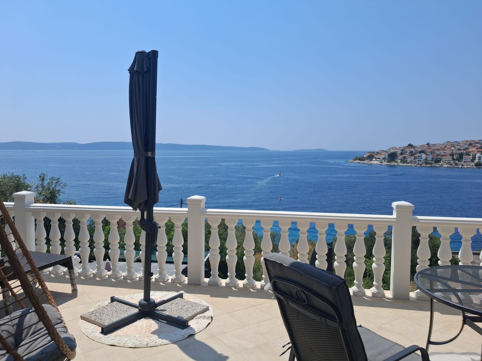 Balkon mit Sonnenschirm und Blick auf die offene Adria